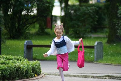 Full length portrait of happy girl standing outdoors