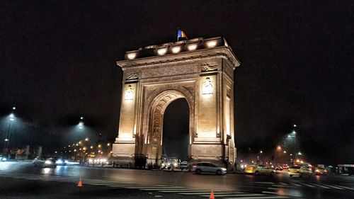 Statue in city at night