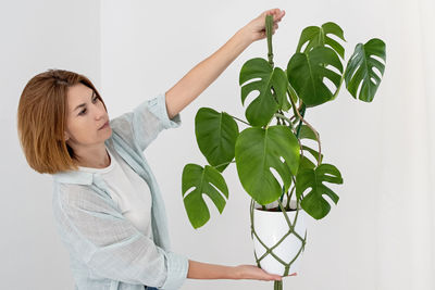 Portrait of young woman against wall