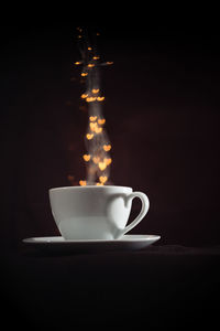 Close-up of coffee cup against black background