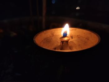 Close-up of lit candle in the dark