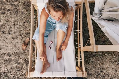 High angle view of thoughtful woman sitting on deck chair