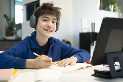 Portrait of smiling boy sitting on table