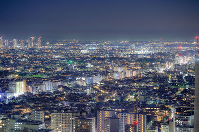 High angle view of illuminated cityscape against sky at night