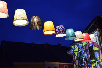 Low angle view of illuminated lanterns hanging against sky