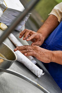 Midsection of senior man preparing food on table