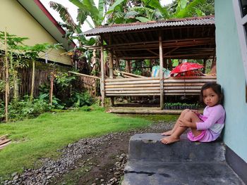 Full length of girl sitting outdoors