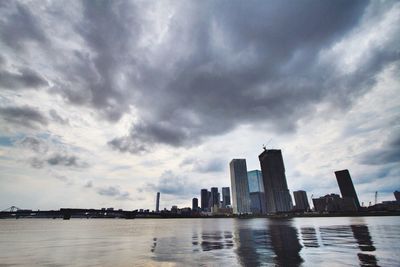 Buildings in city against cloudy sky