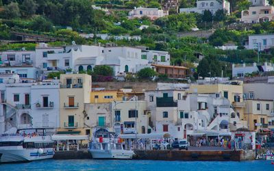 Boats in sea against townscape