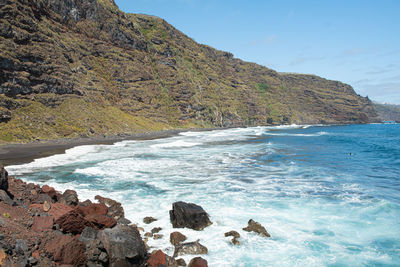 Scenic view of sea and mountains against sky