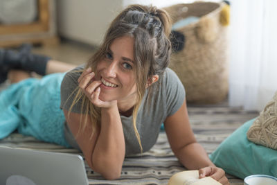 Side view of woman using laptop at home