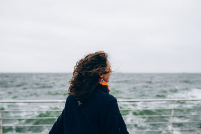 Portrait of happy smiling woman walking outdoor in the sea shore beach on wind weather. person