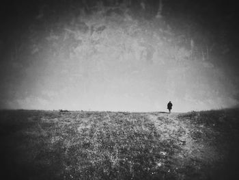 People standing on grassy field against sky