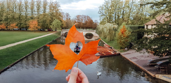 Person holding umbrella by lake