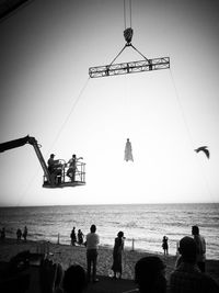 People on beach against clear sky