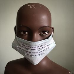 Close-up of mannequin with mask and quotes