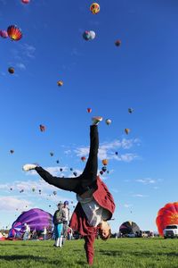 View of hot air balloons flying against blue sky
