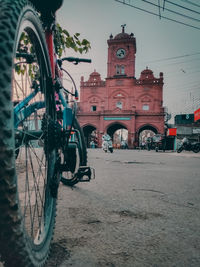 Bicycle parked on street against buildings in city