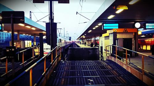 Illuminated railroad tracks in city against sky at night