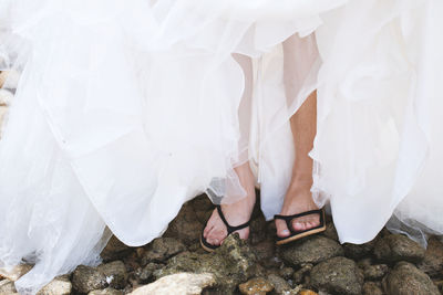Low section of woman standing on footpath
