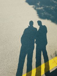 Shadow of men on road