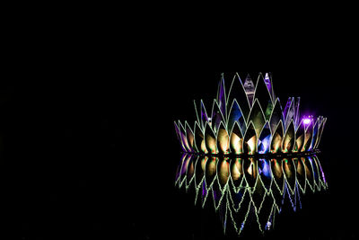 Close-up of illuminated lighting equipment against black background