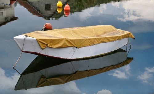 Boat moored on lake against sky