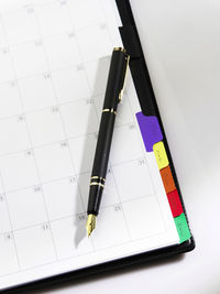 High angle view of pen with diary on table