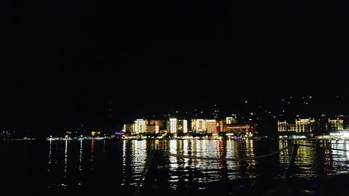 Illuminated cityscape against sky at night