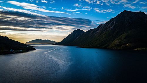 Scenic view of sea and mountains against sky