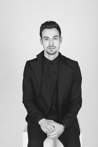 Portrait of young man standing against white background