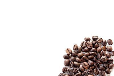 High angle view of coffee beans against white background