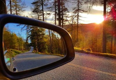 Car moving on road at sunset