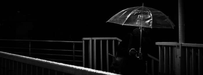 Person holding umbrella standing outdoors