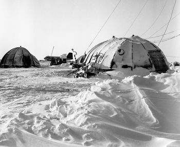 Panoramic view of snow covered land against sky