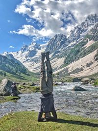 Man doing yoga by river