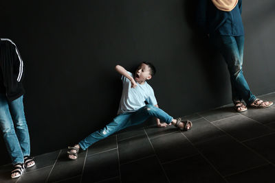 Low section of father and son standing on floor