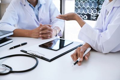 Midsection of doctor examining patient in clinic