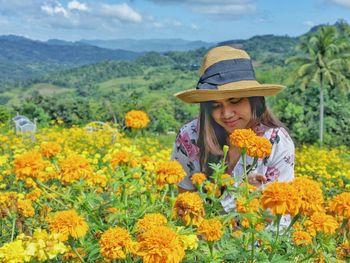 Young woman with yellow flowers in garden