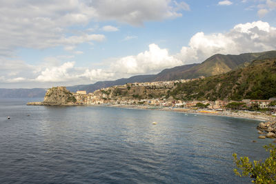 Scenic view of sea and mountains against sky