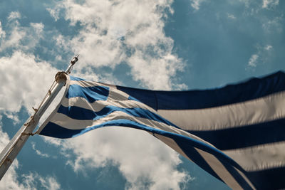 Low angle view of flags against cloudy sky