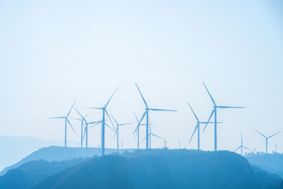 Wind turbines silhouetted on a hilltop