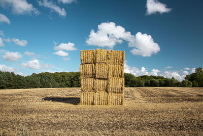 Hay bales on field against sky