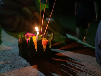 Close-up of hand holding lit candles