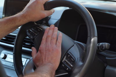 Cropped hand of man driving car