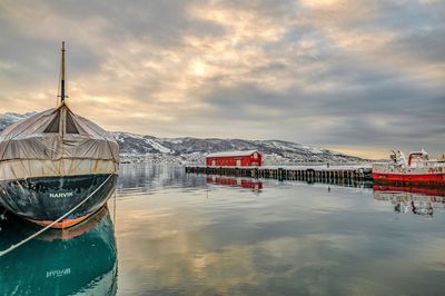 Ship moored at lake against sky during sunset