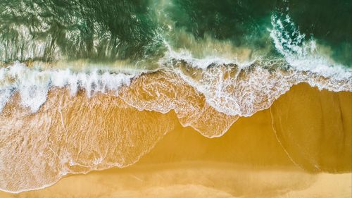 Close-up of water splashing on beach