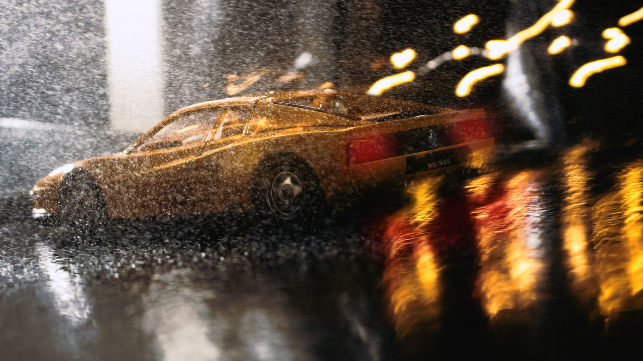 REFLECTION OF ILLUMINATED CAR ON WET STREET IN CITY