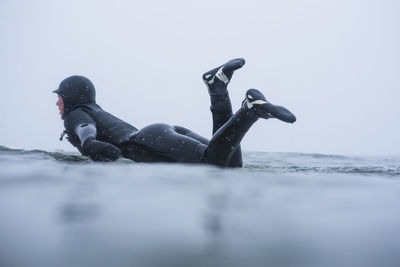 Woman surfing during winter snow