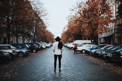 Rear view of person standing on cobblestone street